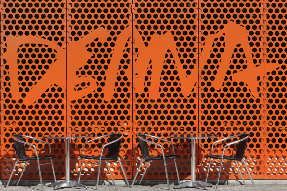 Detail of the facade of Moderna Museet Malmö with café chairs in front 