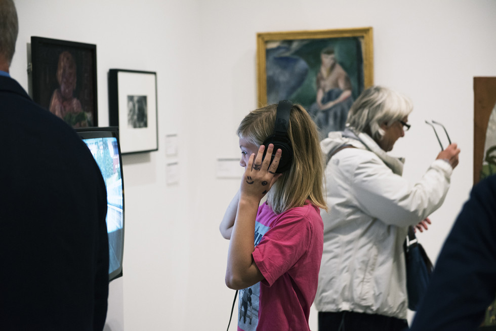 Girl with headphones in front of video screen