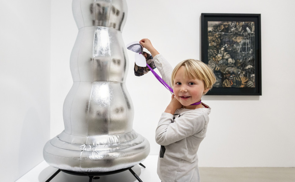 Flicka står framför skulptur