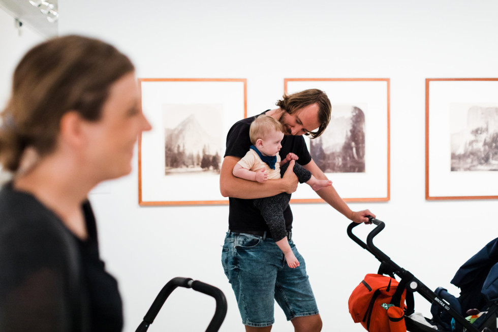 Man carrying baby in exhibition.