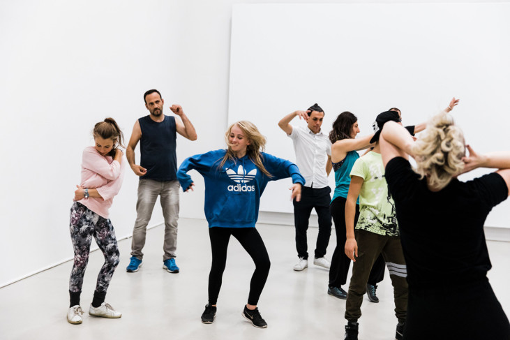 Group of people dancing in exhibition room.