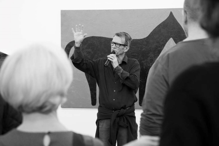 Man speaking in microphone in front of audience.