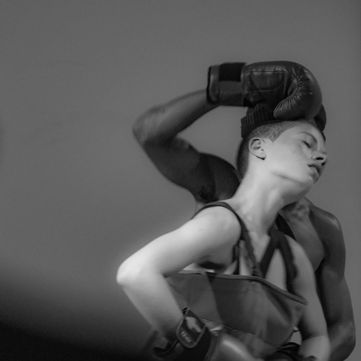 Woman with man´s boxing glove on head.