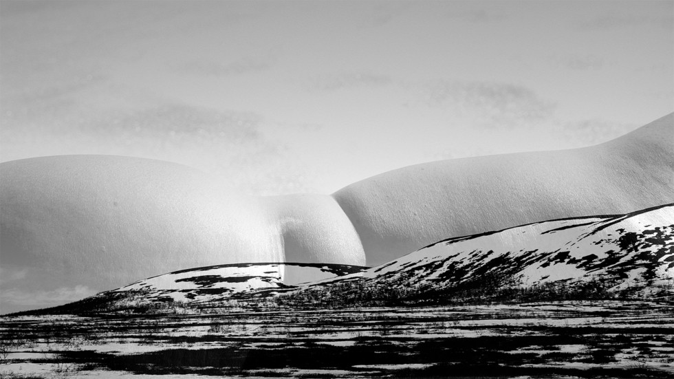 Videostill with mountain and female body.