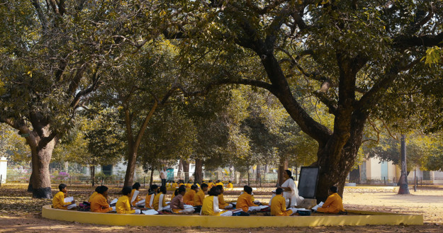 Stillbild från video med ungdomar sittande under träddunge.