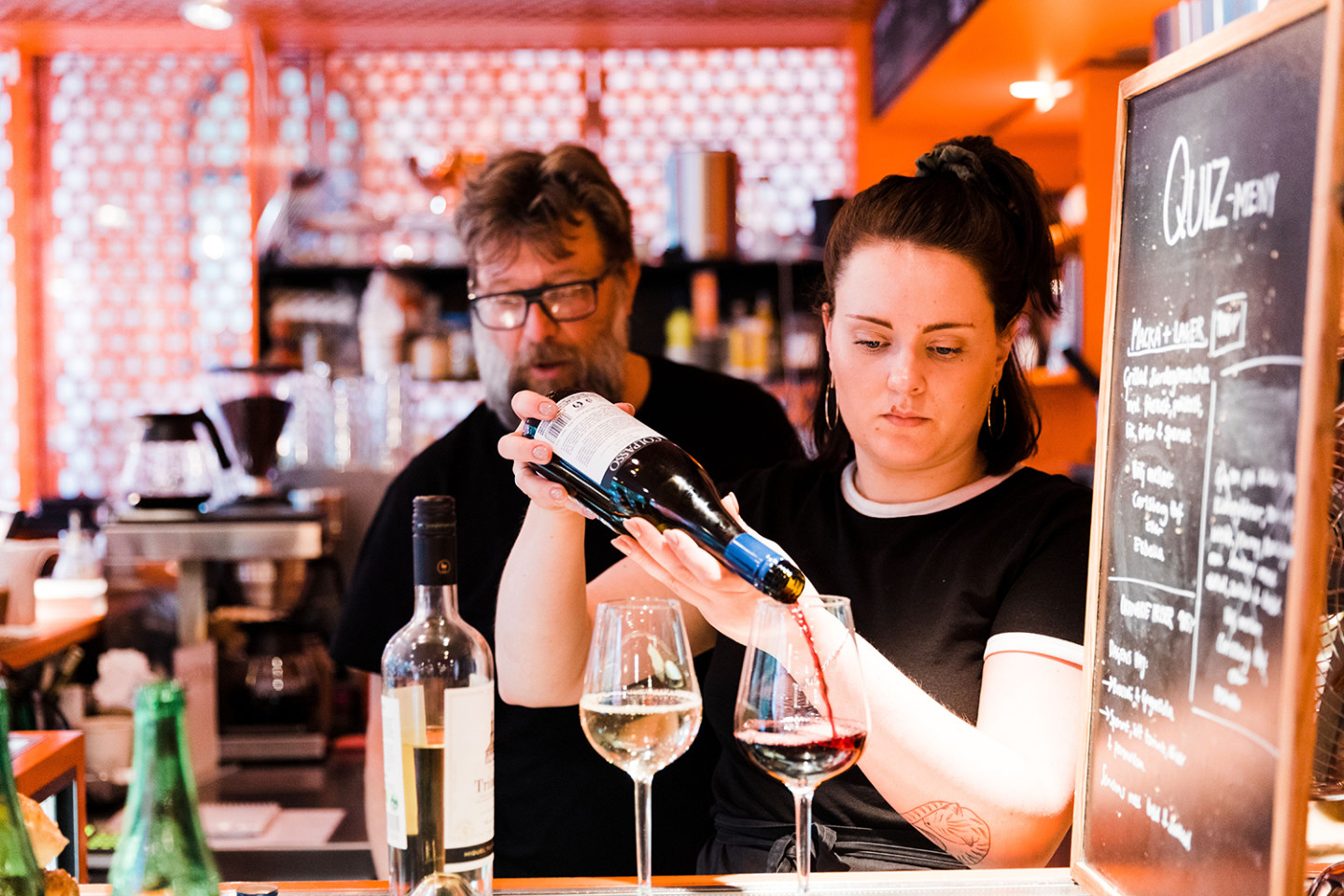 Interior from café with woman serving wine.