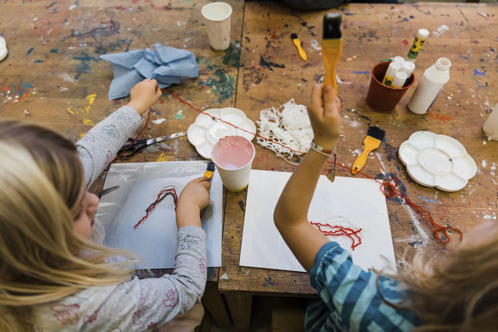 Two children creating at table.