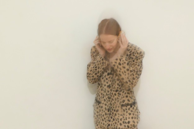 Foto av stående kvinna som håller för sina öron