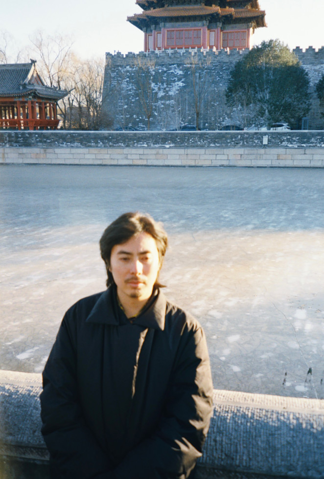 Man standing in front of river and buildings