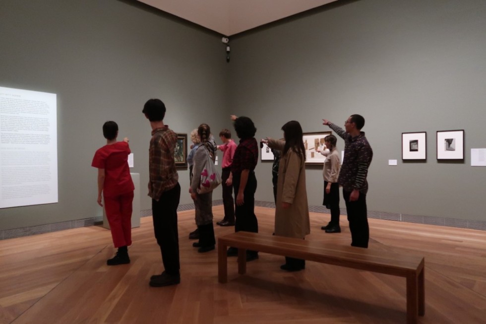 People standing in exhibition room pointing fingers