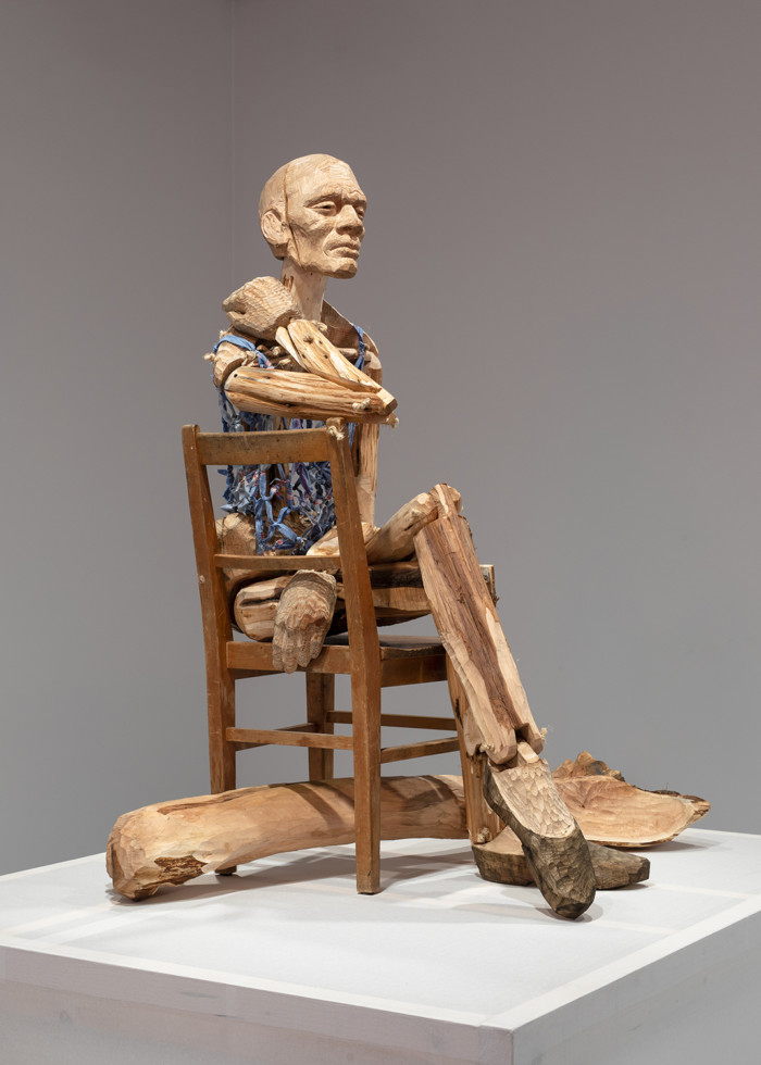 Foto av träskulptur som sitter