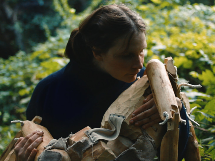 Woman interacting with wooden doll