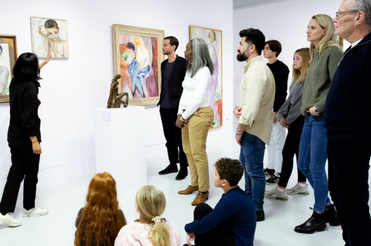People looking at art with guide