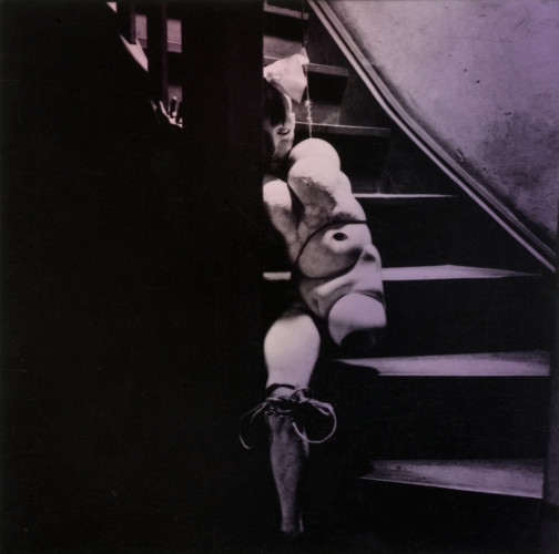 Foto med naken kropp sittande i trappa