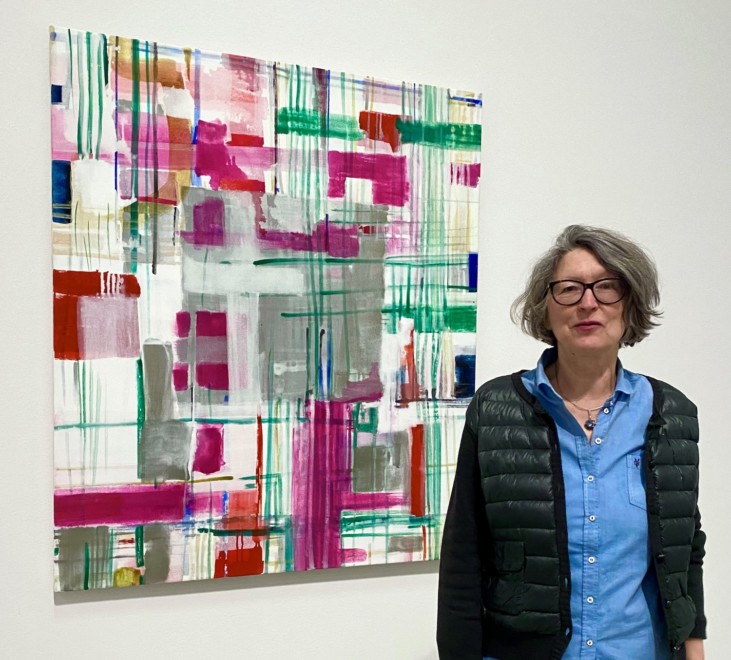 Kvinna stående framför abstrakt målning