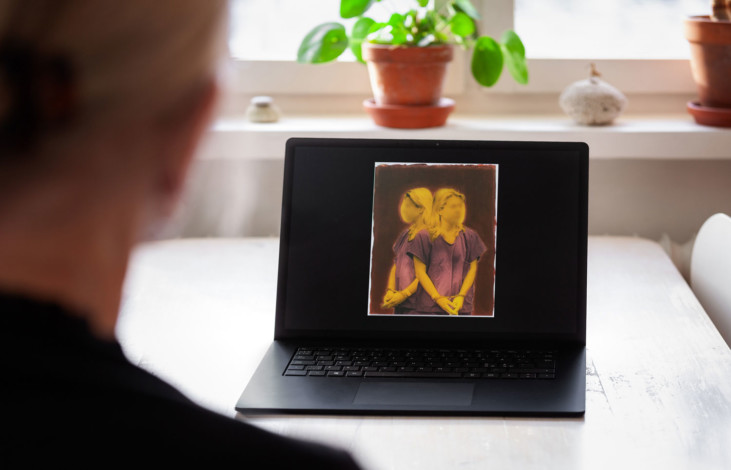 Photo of laptop screen with person looking at it