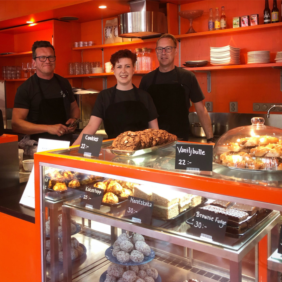 Photo of three people behind cafe desk