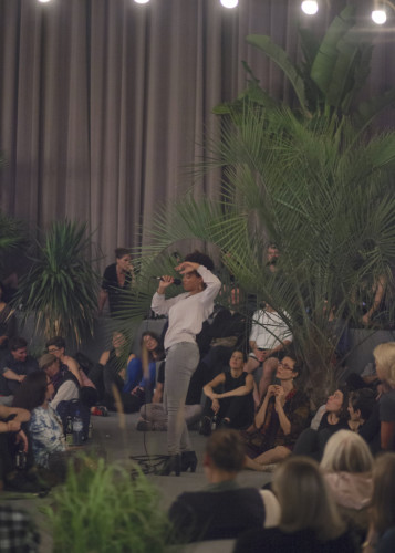 Foto av artist som framträder omgiven av publik