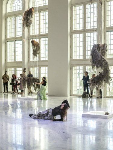 Foto av rum med liggande kvinna på golvet och publik