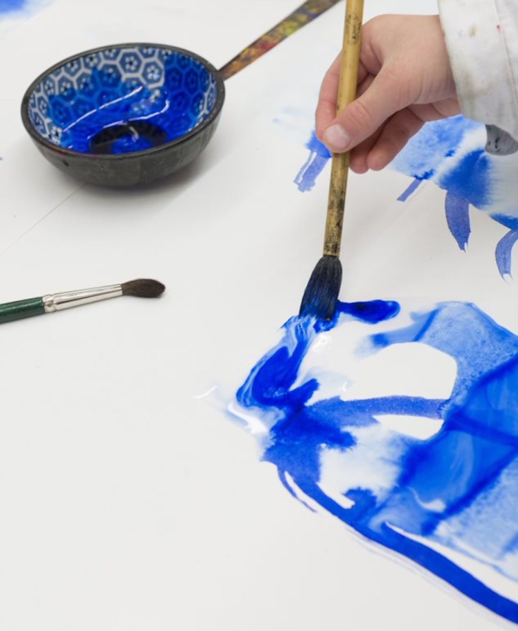 Photo of hand painting with blue watercolors