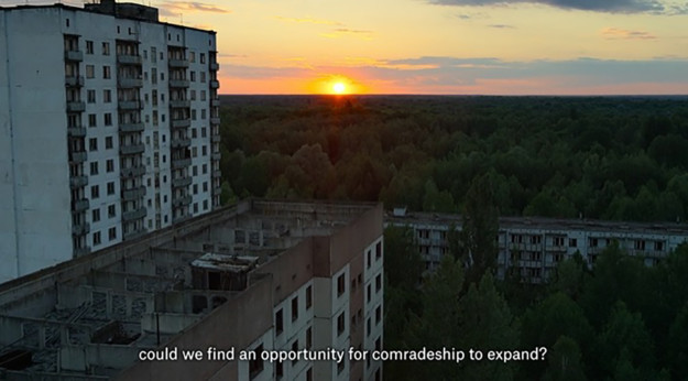 Stillbild från video med byggnader och solnedgång