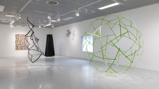 utställningsrum med skulpturer och en målning