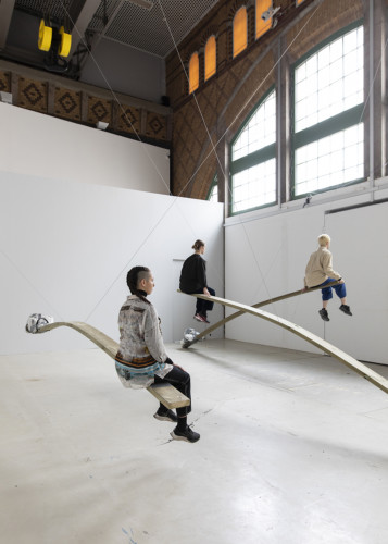 three persons sitting on planks