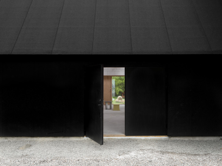 svart husfasad med öppen dörr