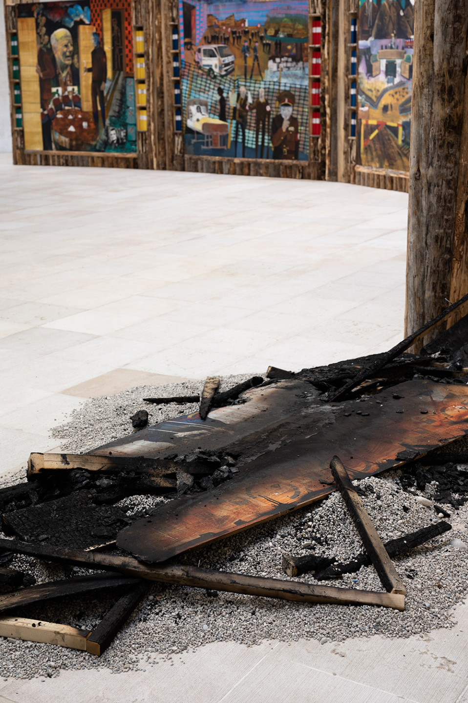 photo of burnt wood and paintings in background