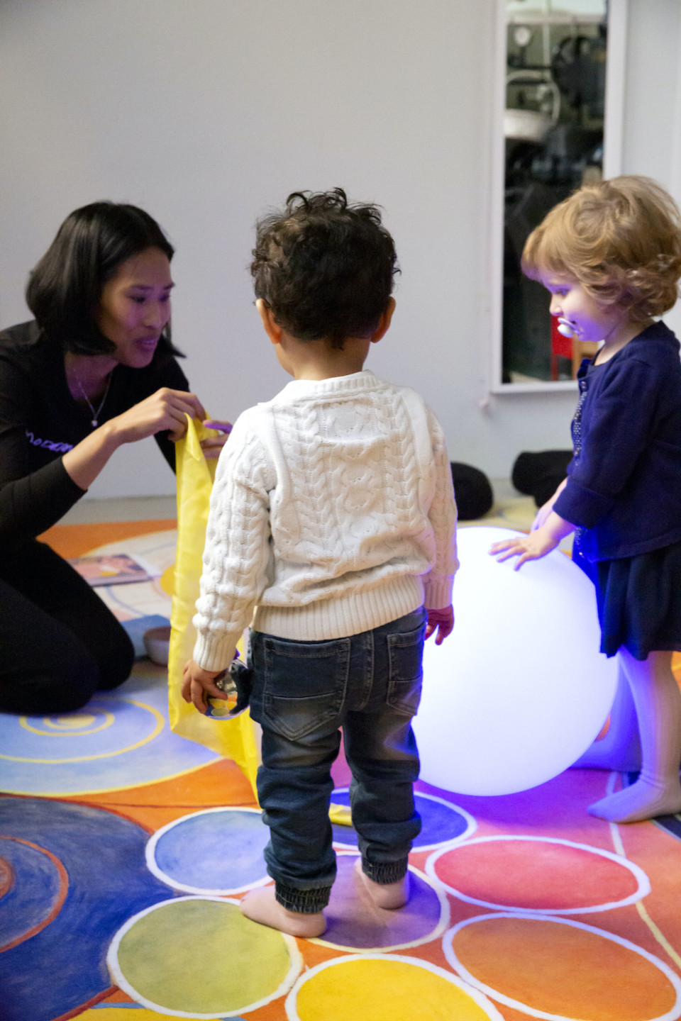 two babies and a woman together in the museums workshop