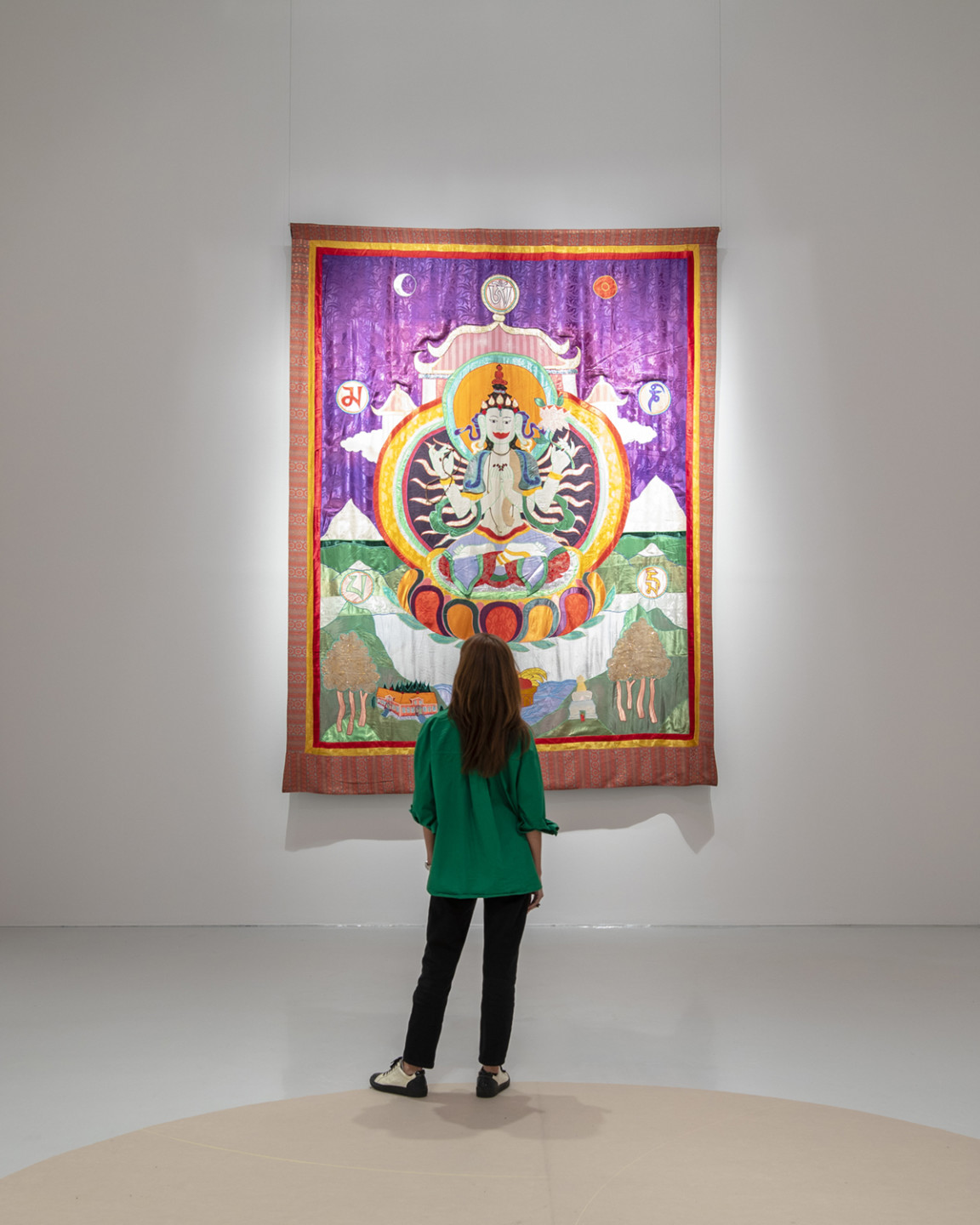 person in front of big textile artwork