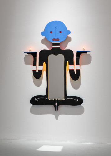 målad figur i trä på vägg