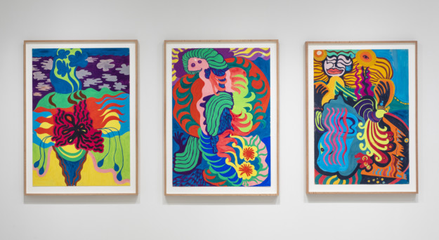 tre målningar i starka färger på vägg