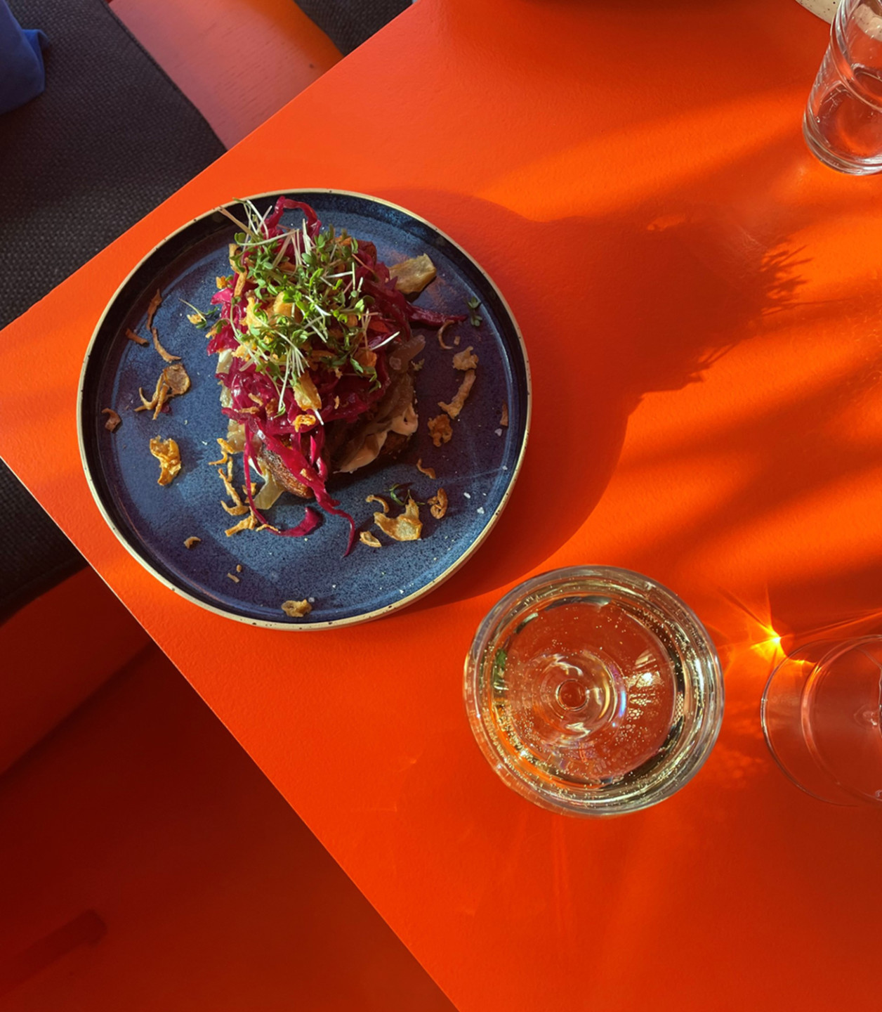 plate with food and glass on orange table