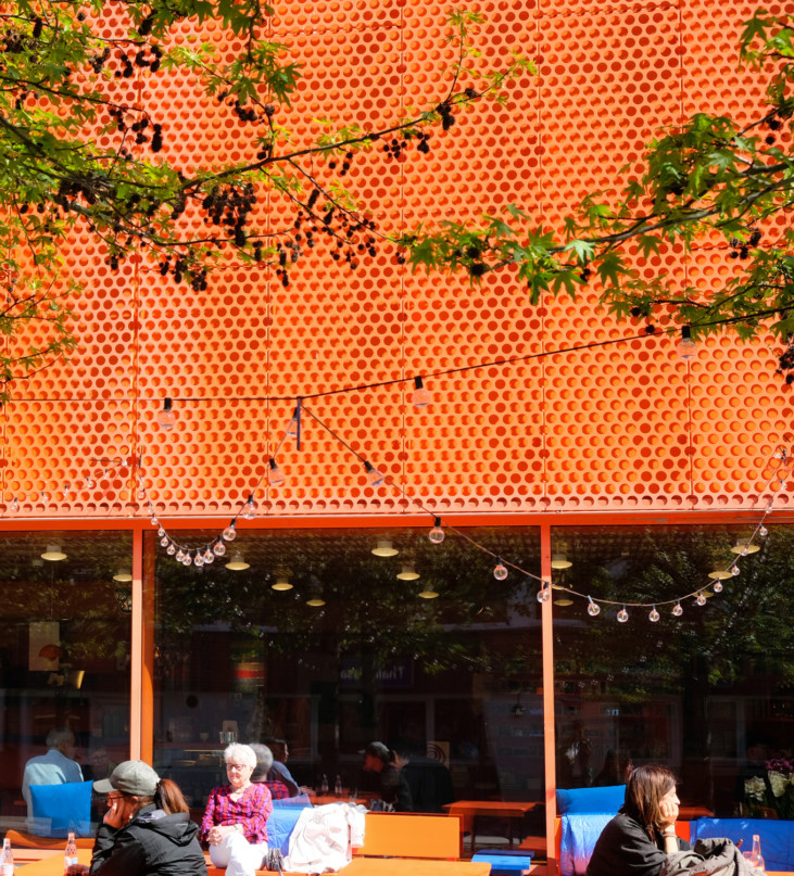 photo av the museum's exterior with people sitting outside