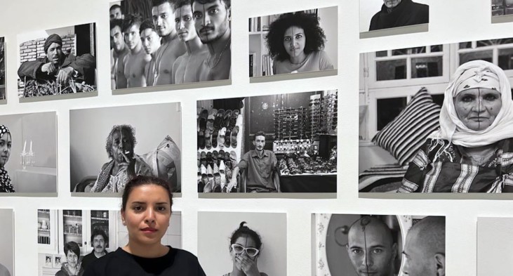woman standing in front of wall with photos