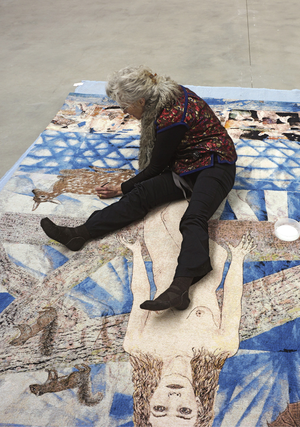 woman sitting on floor with artwork