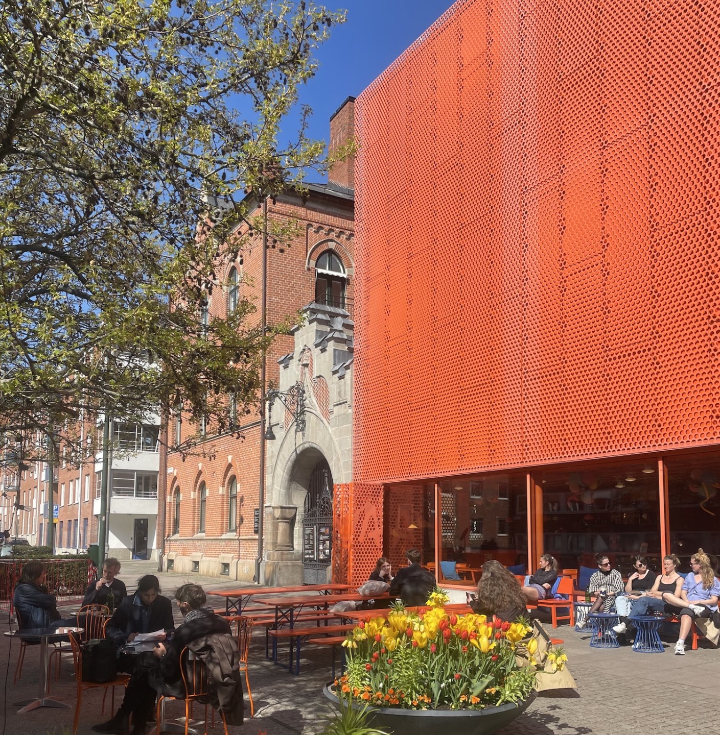 foto av orange byggnad med uteservering