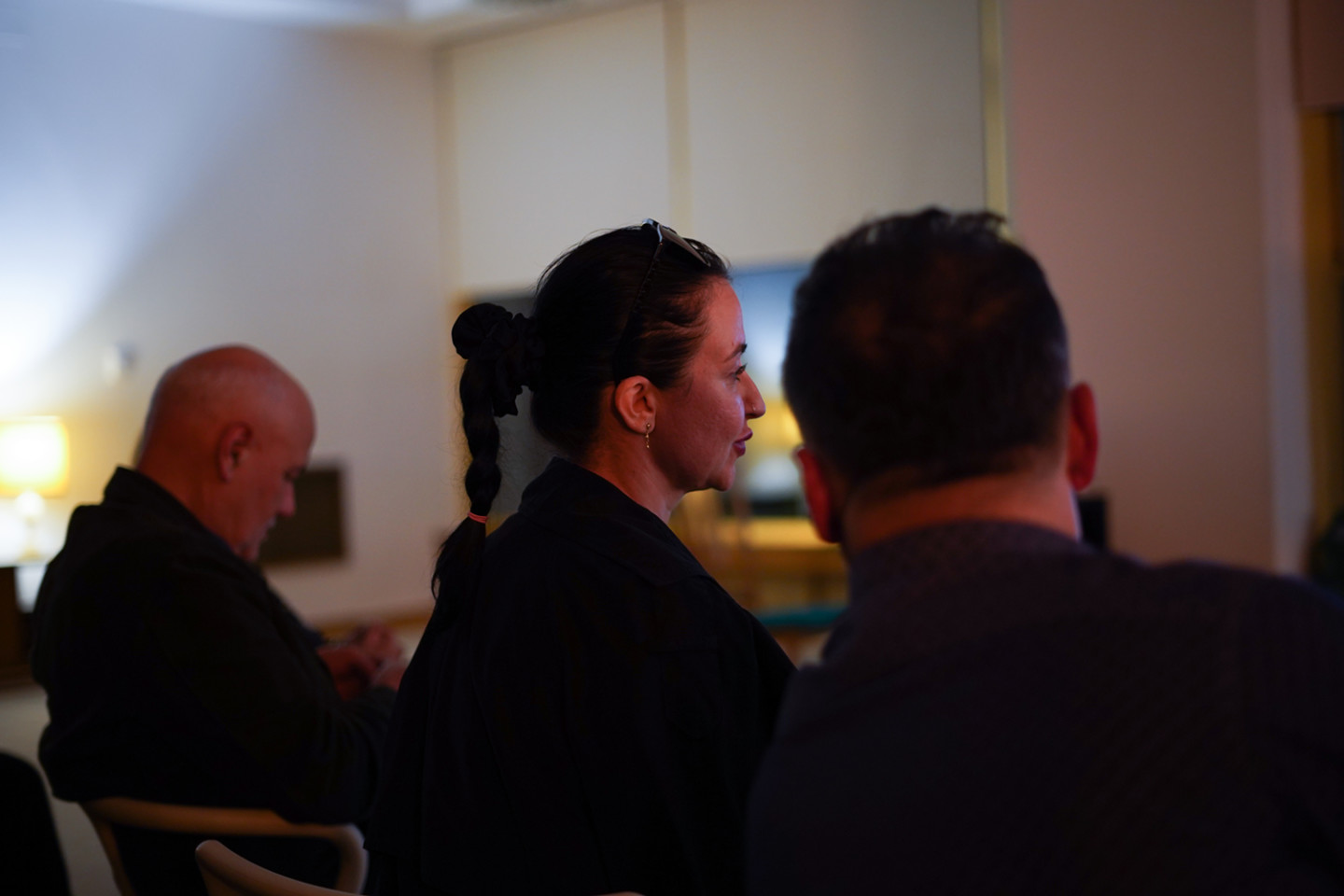 tre personer i sittande publik