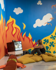 person sitting in front of screen in room with decorated walls