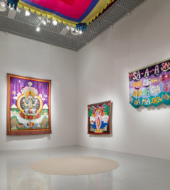 utställningsrum med färgstarka textilier på väggarna
