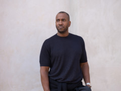 The artist Rashid Johnson stands in front of a plastered facade