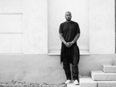 The artist Rashid Johnson stands in front of a plastered facade