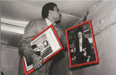 photo of man holding two pictures