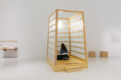 A person sitting in a wooden cubicle