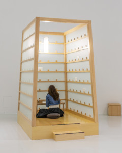 A person sitting in a wooden cubicle