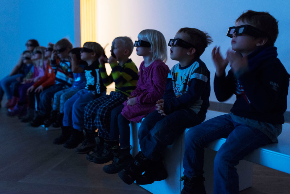 Barn med 3D-glasögon sitter på bänk