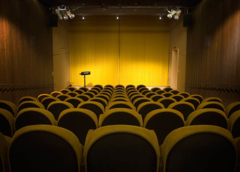 The cinema's yellow interior with cinema seats in the foreground.