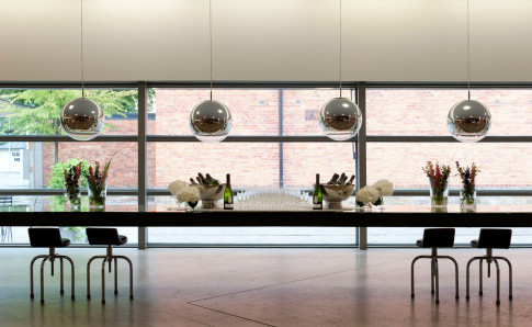 Long table set with champagne and glasses in front of large windows.