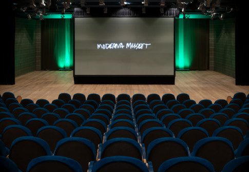 Auditoriets scen med rader av stolar i förgrunden